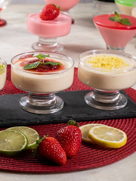 Delicious lemon mousses in glass jars on top of black stone.