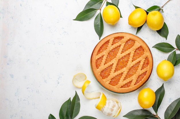 Delicious lemon pie with fresh lemons, top view