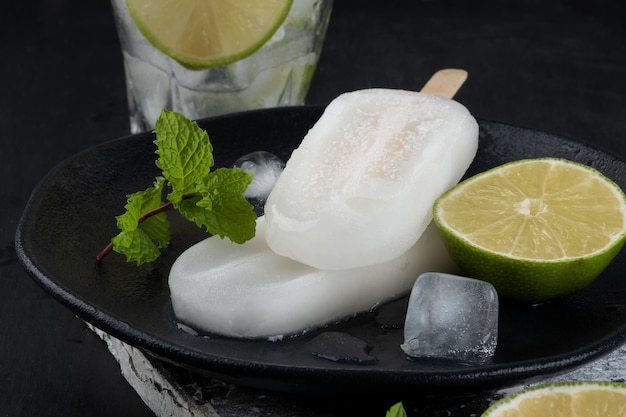 Delicious lemon popsicle on black plate Selective focus