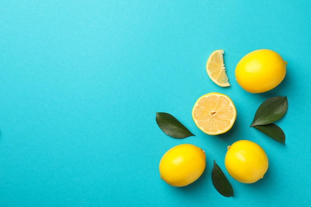 Delicious lemons on turquoise background, space for text