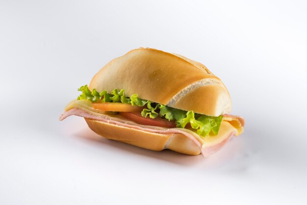 delicious light ham sandwich with lettuce and tomato on white background