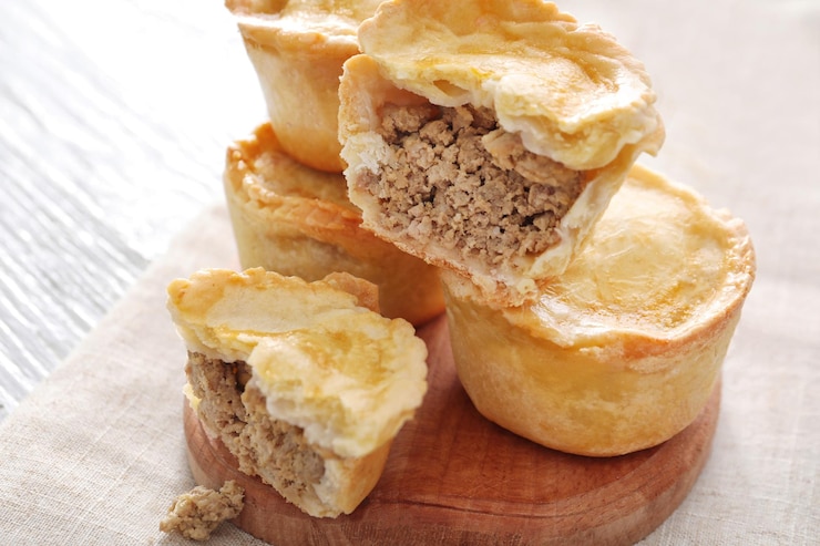 Photo delicious little meat pies on wooden board