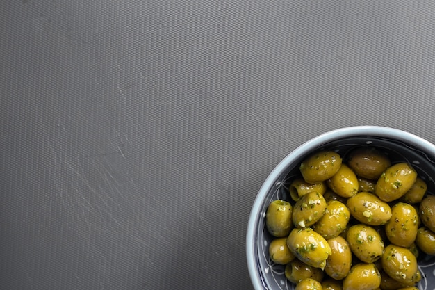 Delicious marinated green olives in a bowl