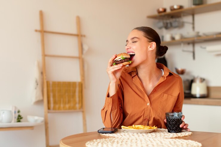 Photo delicious meal hungry woman eating homemade burger lady holding and biting tasty fast food enjoying