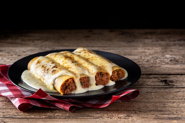 Delicious meat cannelloni pasta on rustic wooden table