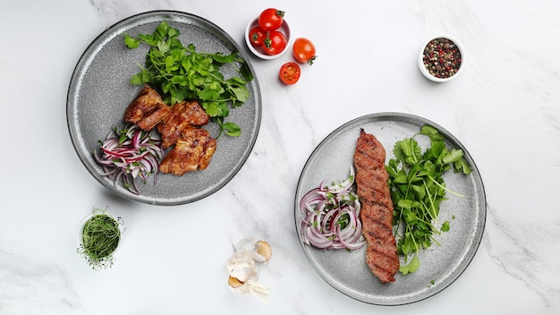 Delicious meat kebab with fresh vegetable. Grilled meat kebabs, vegetables on a marble table