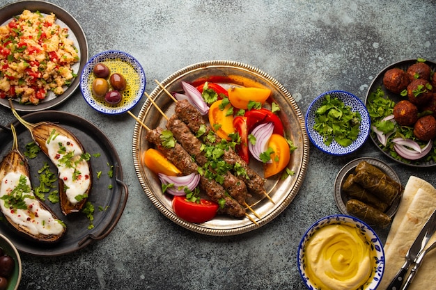 新鮮な野菜のサラダを添えたおいしい肉のケバブに、さまざまな中東料理と前菜を添えて。アラブ料理とメゼの盛り合わせ、美味しくてヘルシーな地中海料理の上面図