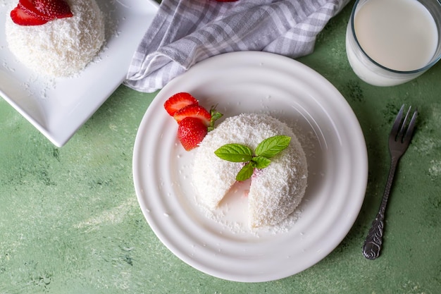 Delicious milk dessert; cup dessert with coconut and strawberry (Turkish name; fincan tatlisi