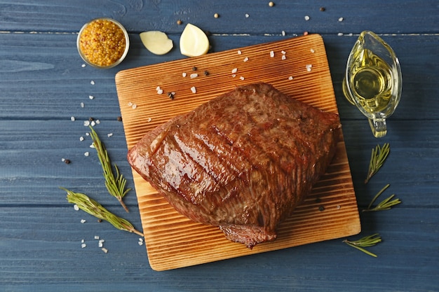 Delicious moist steak on board and blue wooden table