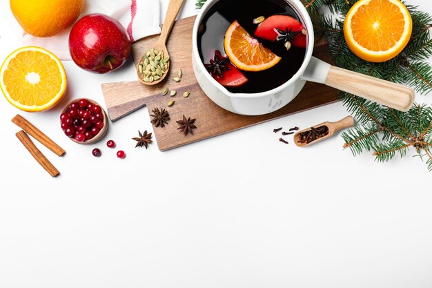 Delicious mulled wine and ingredients on white table flat lay Space for text