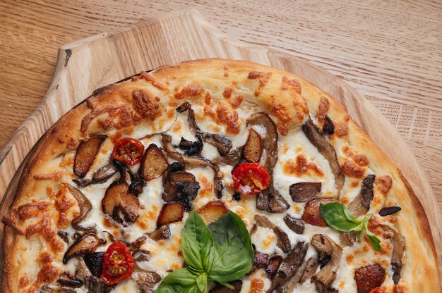 Delicious mushroom pizza on wooden background