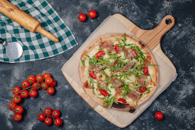 Delicious Neapolitan pizza on board with cherry tomatoes