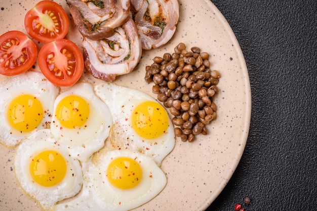 Delicious nutritious breakfast of fried quail eggs bacon legumes and cherry tomatoes