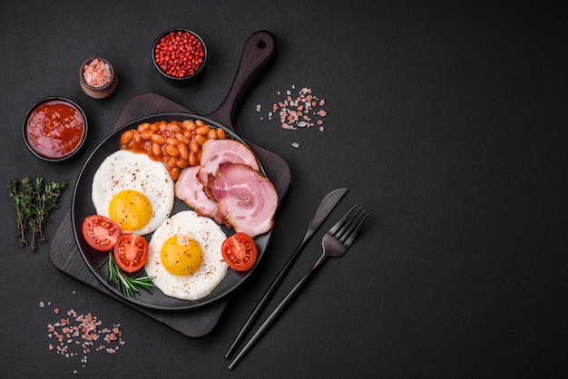 Delicious nutritious English breakfast with fried eggs and tomatoes