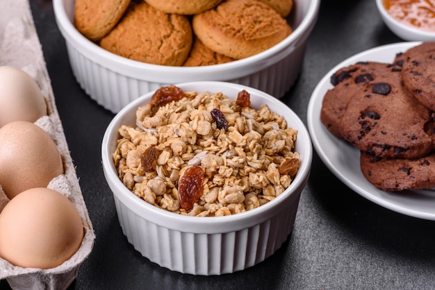 グラノーラ卵オーツ麦クッキーミルクとジャムを使ったおいしい栄養価の高い健康的な朝食一日の始まりに健康的な食事