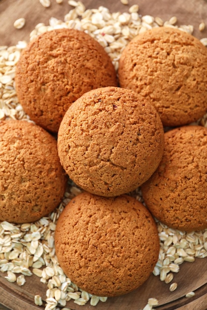 Delicious oatmeal cookies on wooden board closeup