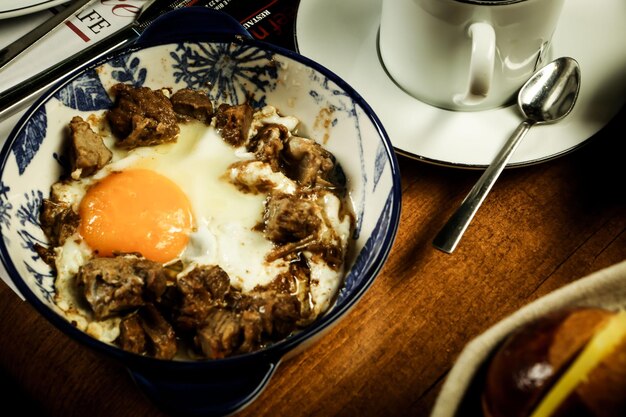 Вкусный омлет с мясом и тарелкой для завтрака на столе