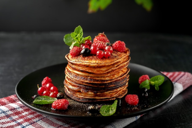 Delicious, only baked pancakes with fresh fruits of raspberries, currants and strawberries