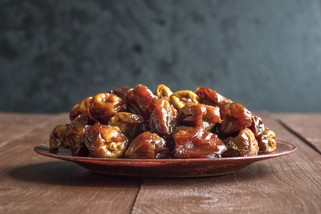 Delicious organic sweet dates in bowl with syrup. Iftar dates.