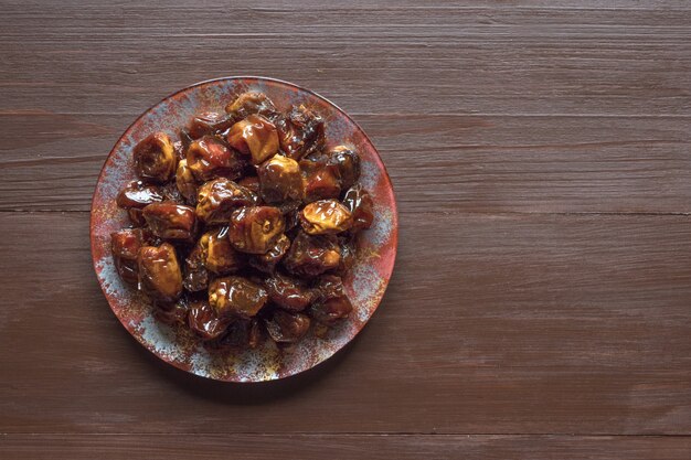 Delicious organic sweet dates in bowl with syrup