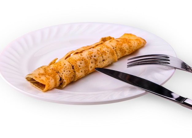 Delicious pancake liver cut into pieces on a white plate with a metal knife and fork