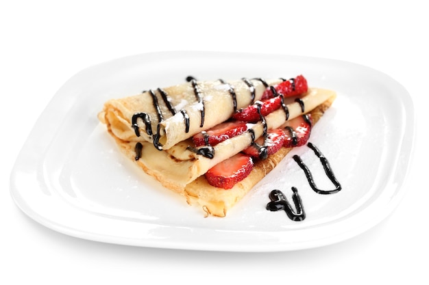 Delicious pancake with strawberries and chocolate on plate isolated white