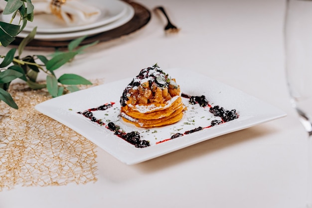 Delicious Pancakes are served with currant jam and apples on a plate ready for eat