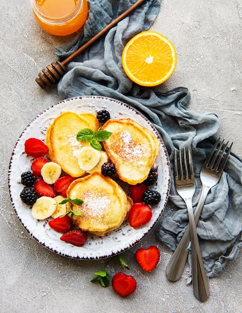 Delicious pancakes with berries on a concrete backrgound