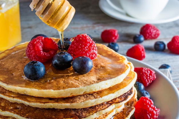 Delicious pancakes with berries and honey