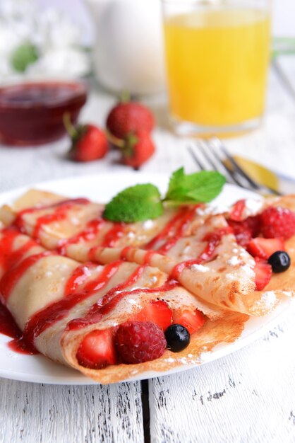 Delicious pancakes with berries on table close-up