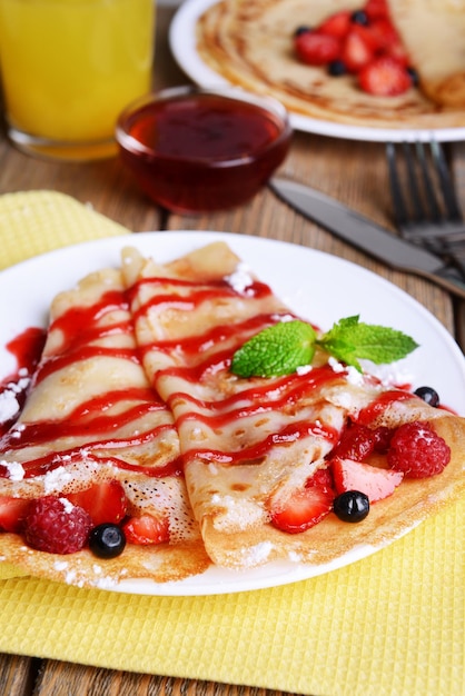 Delicious pancakes with berries on table closeup