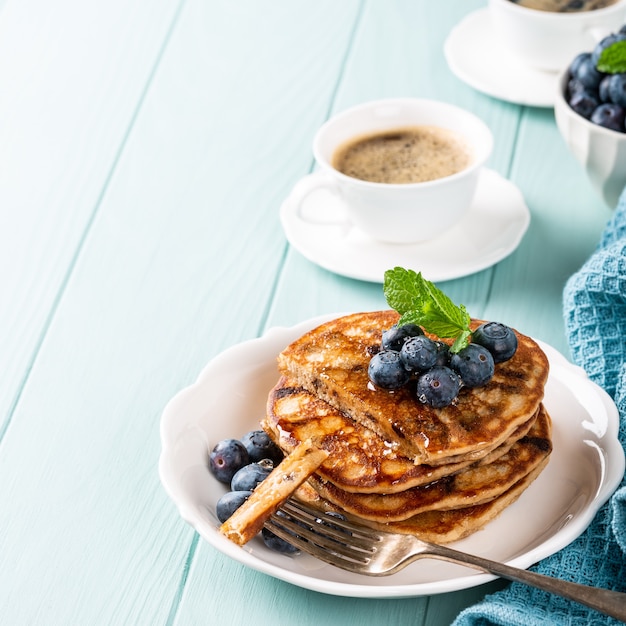 Delicious pancakes with chocolate drops, honey and blueberries. Healthy breakfast concept with copy space