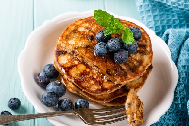 Delicious pancakes with chocolate drops, honey and blueberries. Healthy breakfast concept