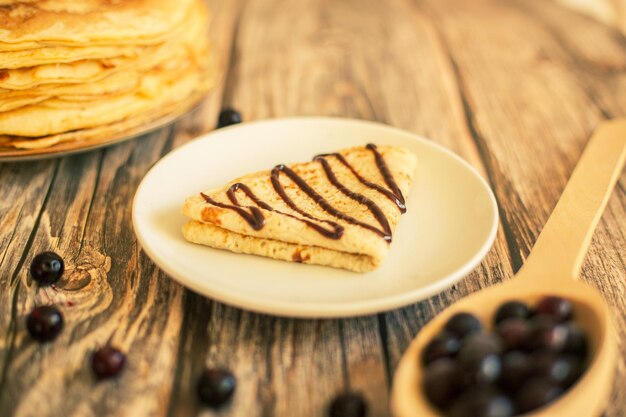 Delicious pancakes with chocolate sauce fresh blueberries on a rustic wooden table rustic brown tabl