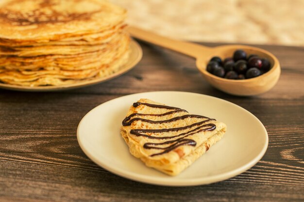 Delicious pancakes with chocolate sauce fresh blueberries on a rustic wooden table rustic brown tabl