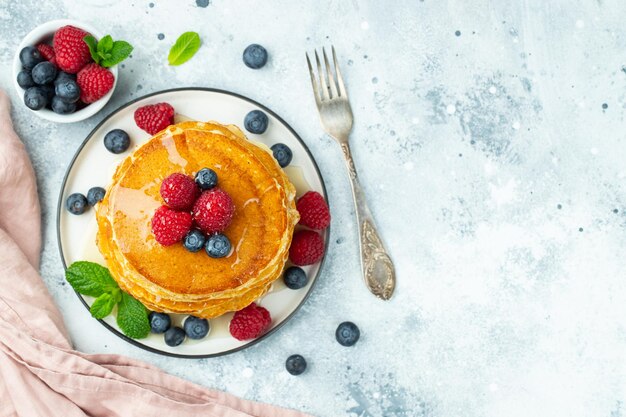 Delicious pancakes with fresh berries and honey