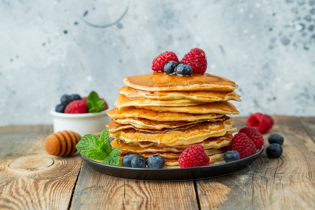 Delicious pancakes with fresh berries and honey