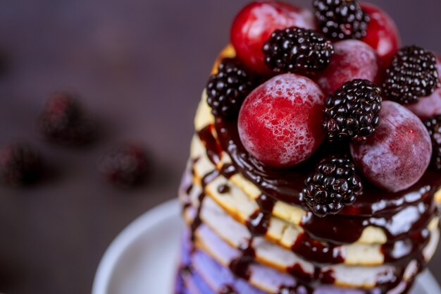 Delicious pancakes with grape, berry jam on wooden table