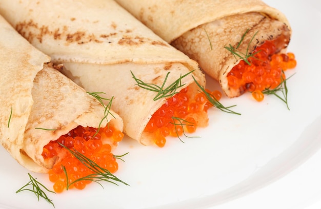 Delicious pancakes with red caviar on plate closeup