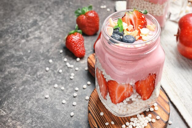 Delicious parfait with fruits in jar on table