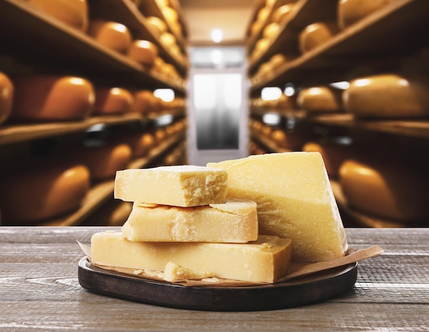 Вкусный сыр пармезан на деревянном столе на складе