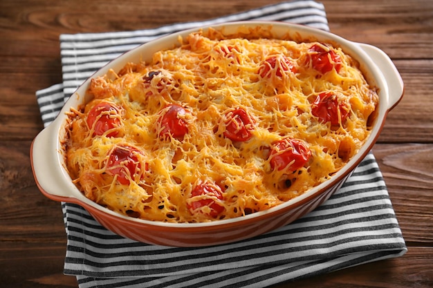 Delicious pasta Al Forno in ceramic bowl on wooden table