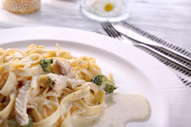 Photo delicious pasta alfredo with chicken on plate closeup