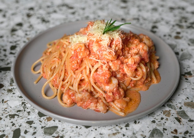 Вкусные макароны спагетти с креветками, томатным соусом и сыром на тарелке
