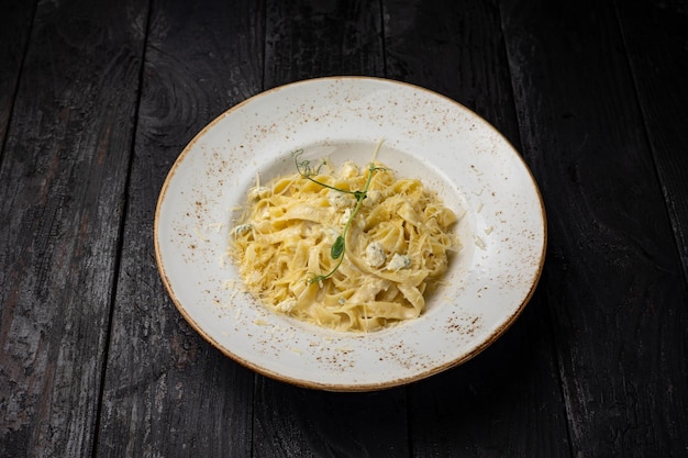 delicious pasta with cheese, greens, sauce in a restaurant