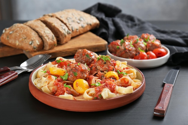 Вкусные макароны с фрикадельками и томатным соусом на тарелке
