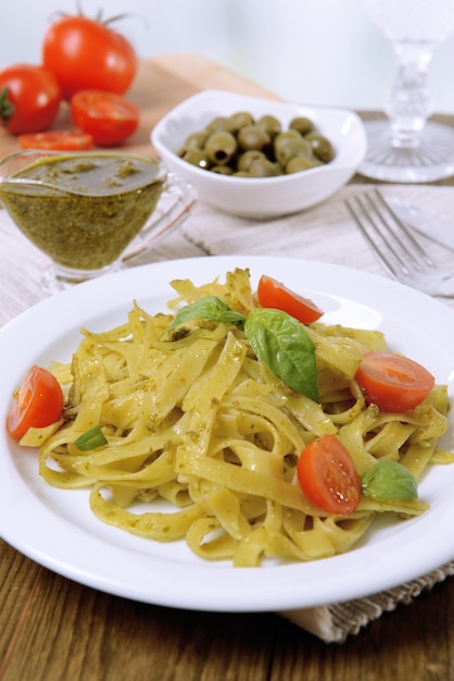 Delicious pasta with pesto on plate on table closeup