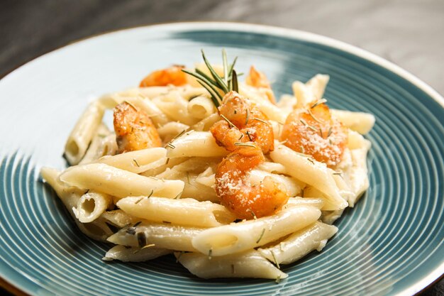 Delicious pasta with shrimps on plate closeup