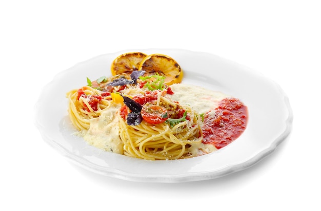흰색 배경에 대해 접시에 토마토 소스와 야채를 곁들인 맛있는 파스타