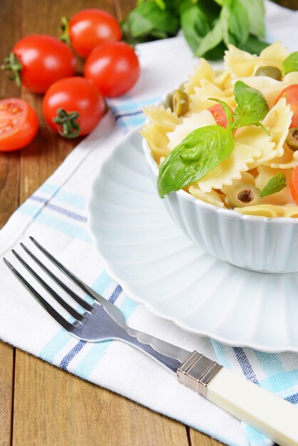 Delicious pasta with tomatoes on plate on table close-up